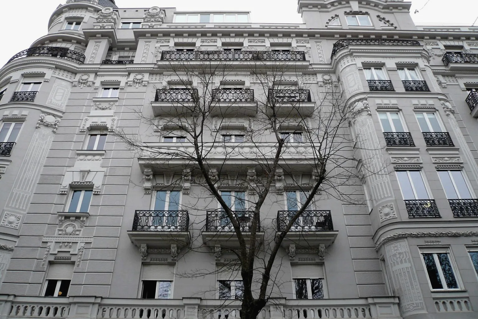 Classical façade of a residential building on Calle de Almagro, Madrid, with wrought-iron balconies.